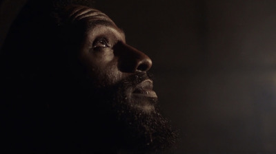 a man with a beard looking up at the light