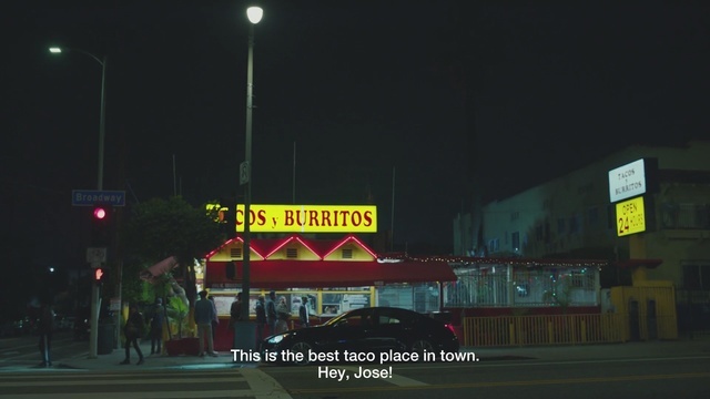 a fast food restaurant with a red awning at night