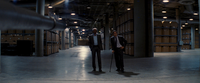 a couple of men standing next to each other in a warehouse