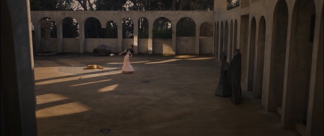 a woman in a white dress standing in a courtyard