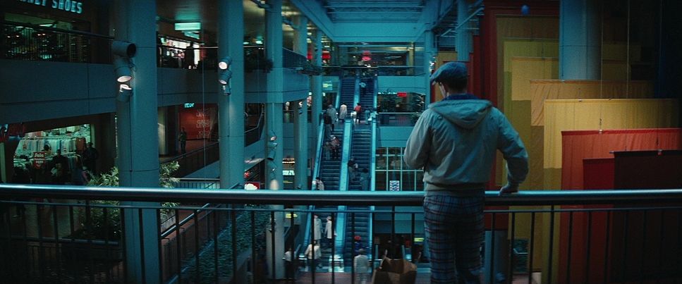 a man standing on a balcony looking at a building