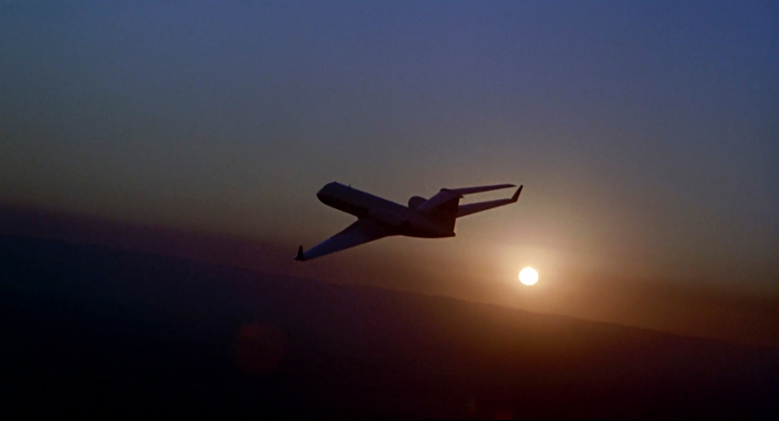 a large jetliner flying through a sunset sky