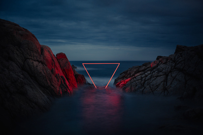 a long exposure photo of a red light at the end of a tunnel between two