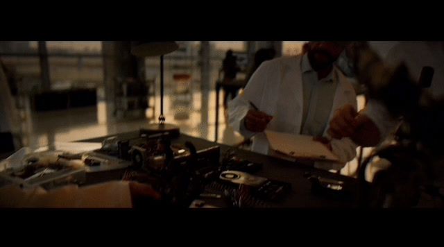 a man in a white shirt and tie making something