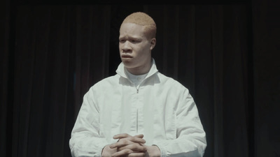 a man standing in front of a black curtain