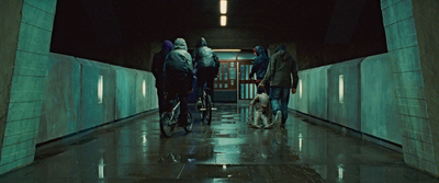 a group of people riding bikes down a hallway