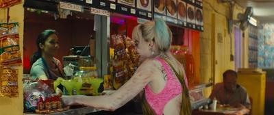 a woman in a pink top standing in front of a store