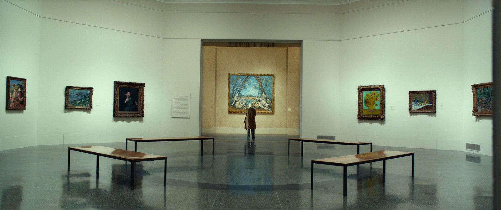 a person standing in a room with paintings on the walls