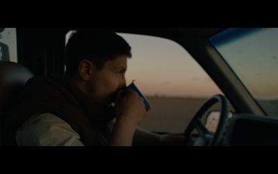 a man sitting in a car talking on a cell phone