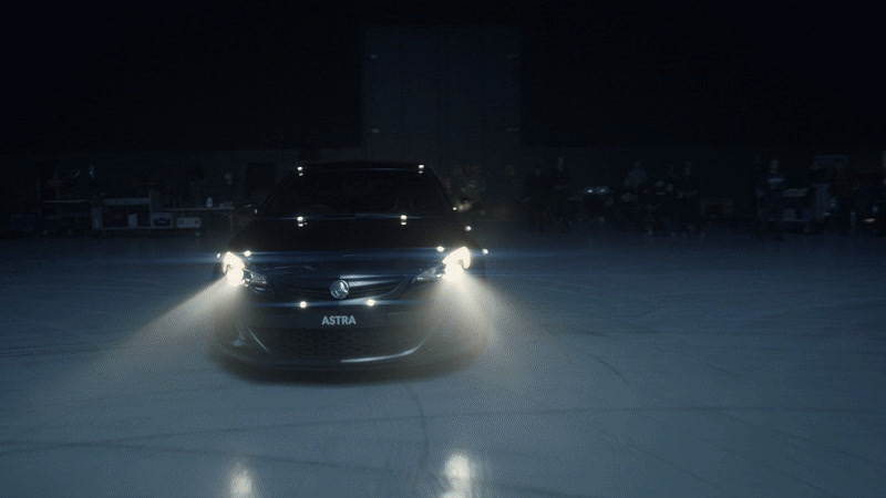 a car driving through a parking lot at night