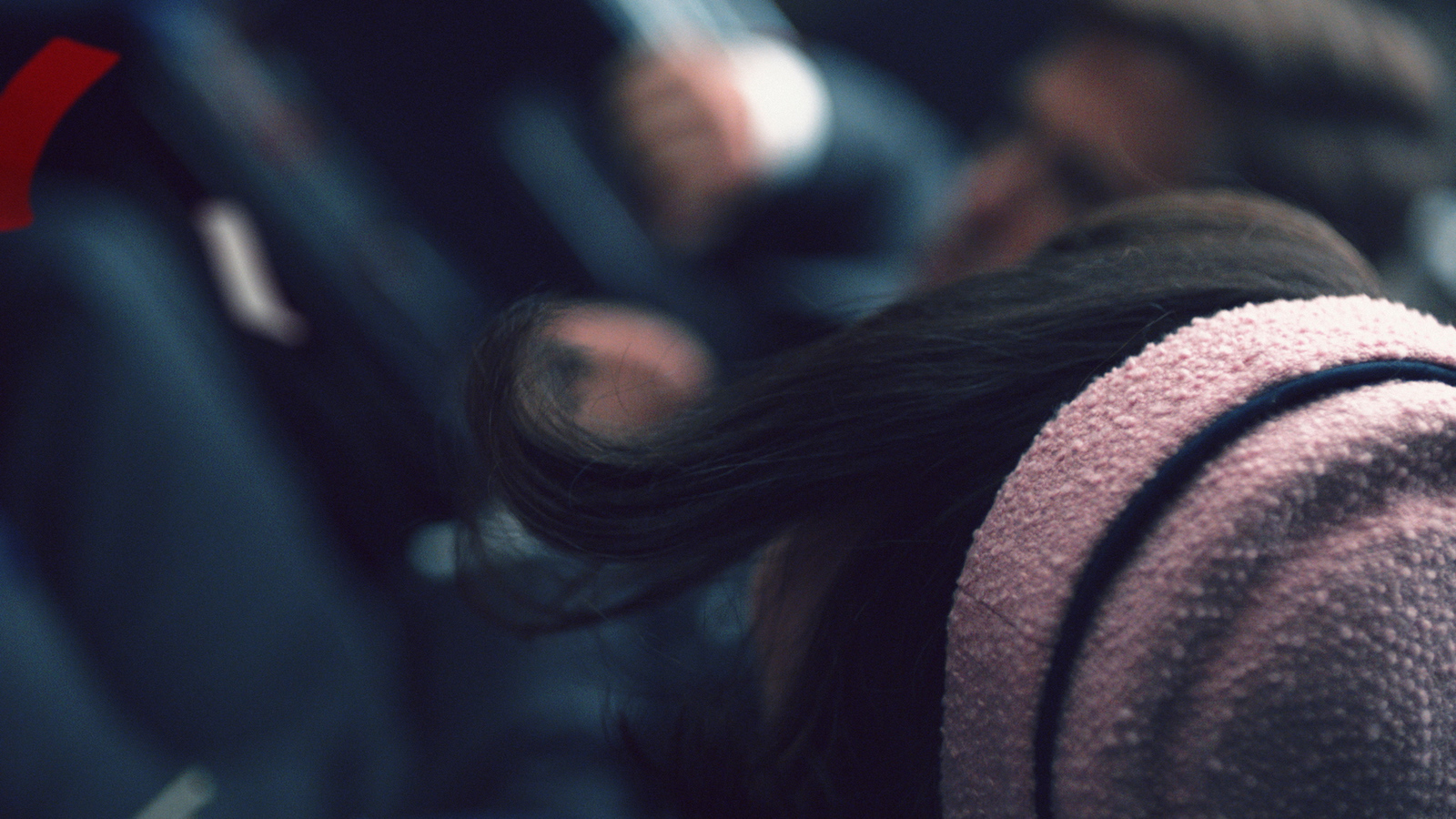 a woman with her hair in a ponytail sitting in a seat