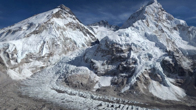 a snow covered mountain range under a blue sky