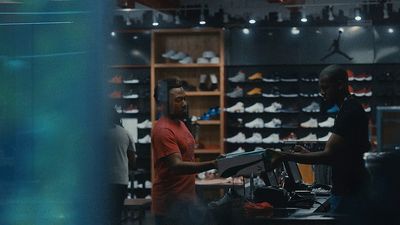 a couple of men standing in a shoe store