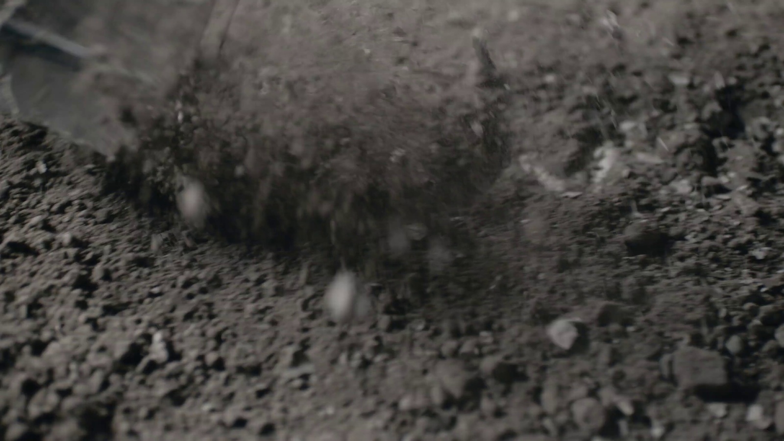 a black and white photo of dirt and a shovel