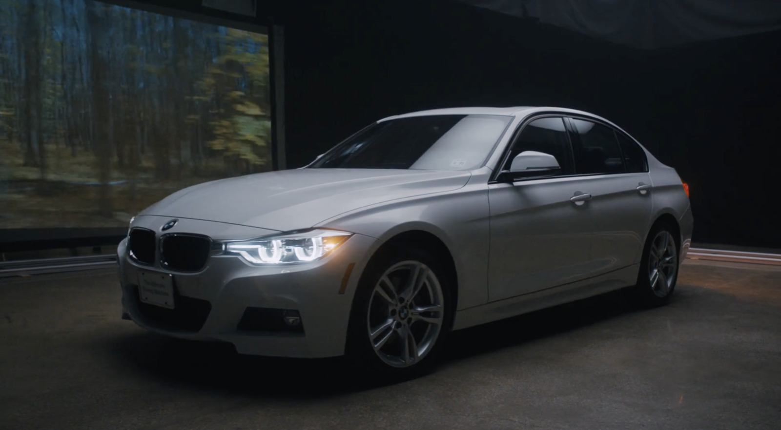 a white car is parked in a dark room