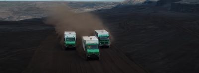 three green and white trucks driving down a dirt road