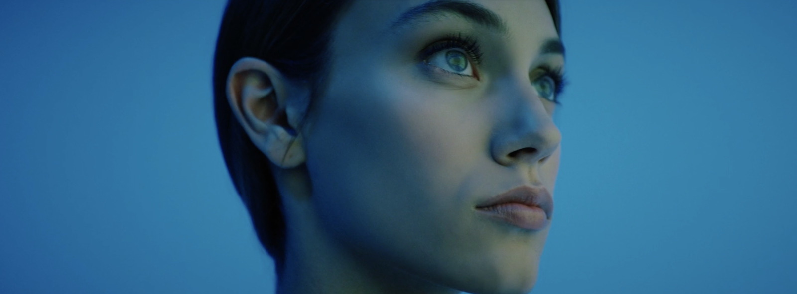 a close up of a woman's face with a blue background