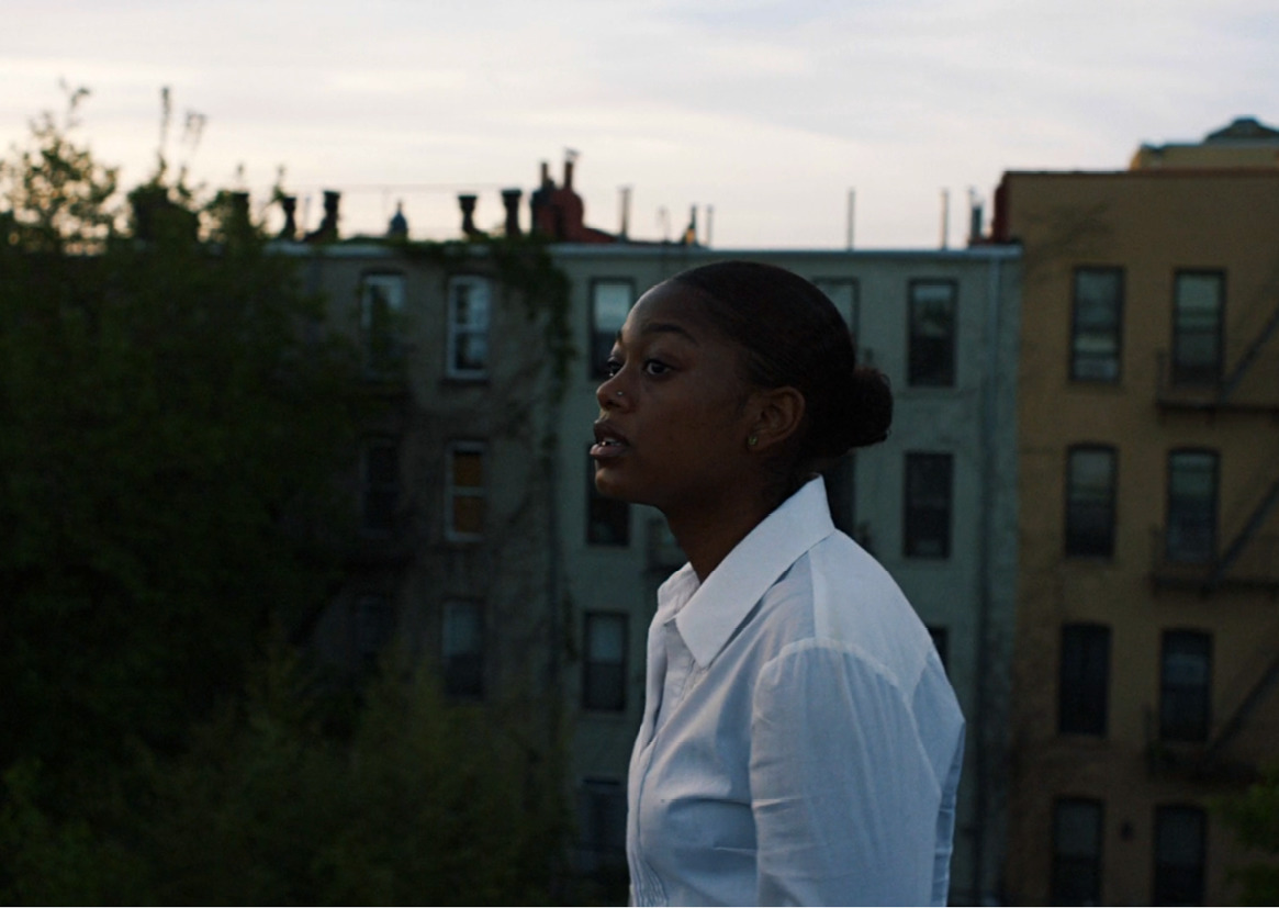 a woman in a white shirt standing on a balcony