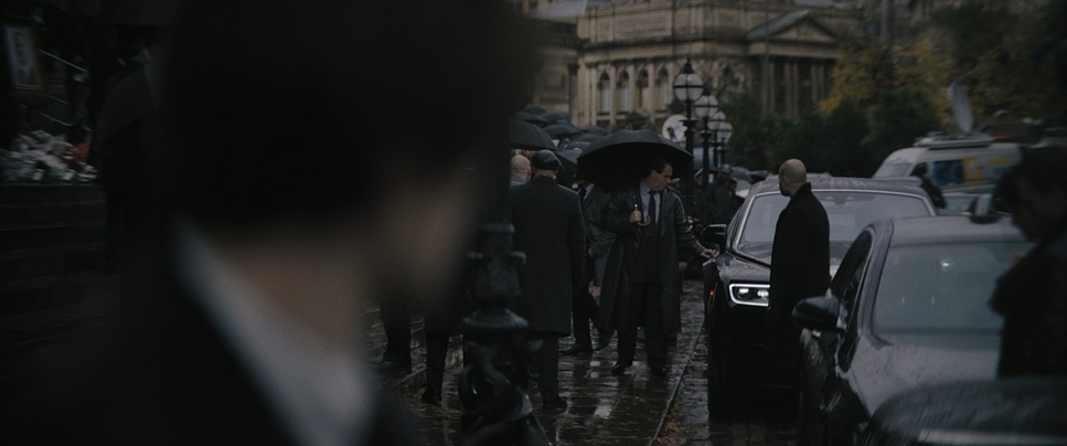 a group of people walking down a street holding umbrellas