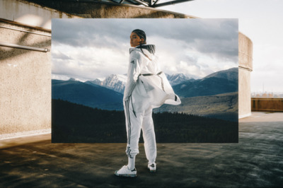 a woman standing in front of a picture of mountains