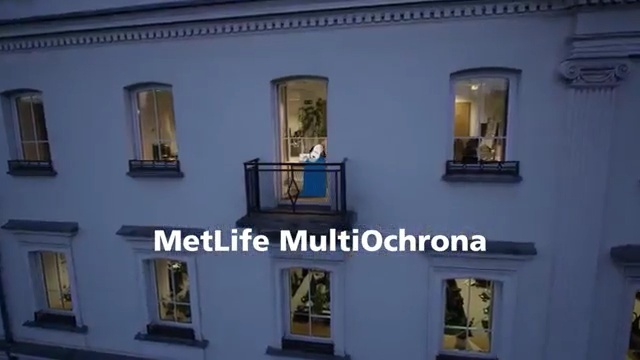 a large white building with a balcony and windows