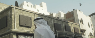 a person wearing a white veil standing in front of a building