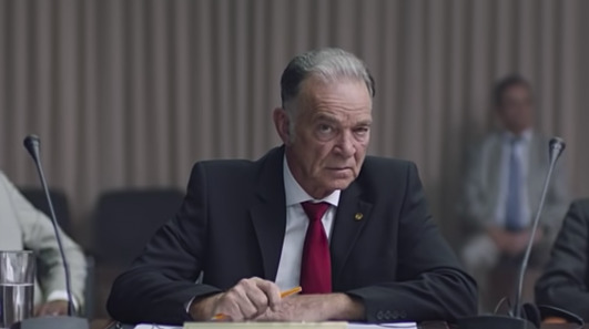 a man in a suit and tie sitting at a table