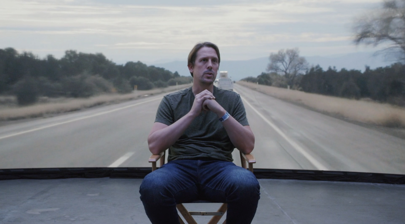 a man sitting in a chair on the side of a road