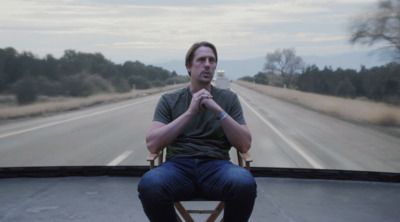 a man sitting in a chair on the side of a road