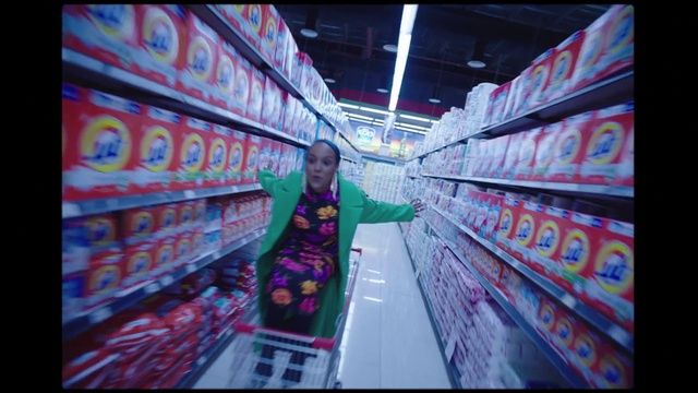 a woman is standing in a grocery store aisle