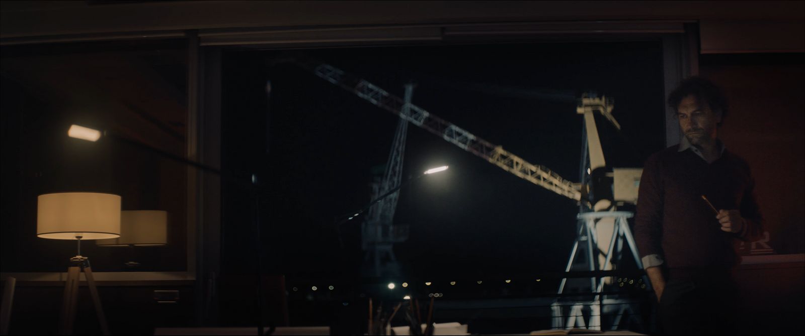 a man standing in front of a window at night