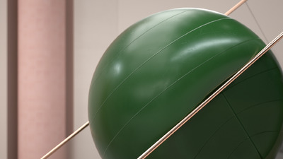 a large green ball and some sticks in a room