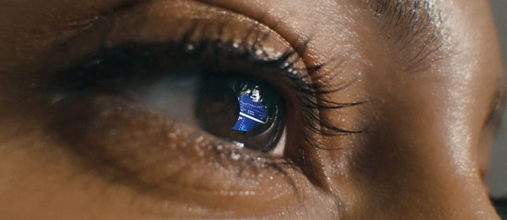 a close up of a person's eye with a blue shirt on