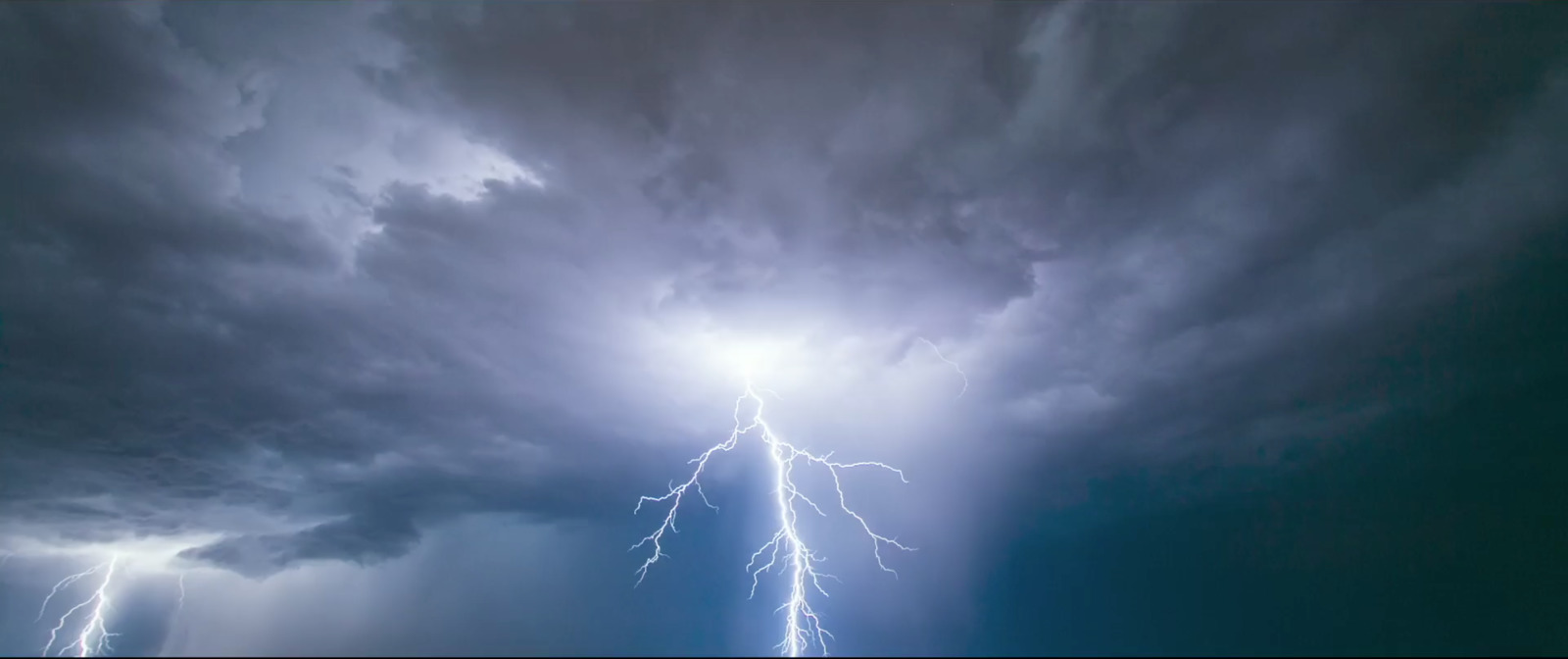 a lightning bolt hitting through a cloudy sky