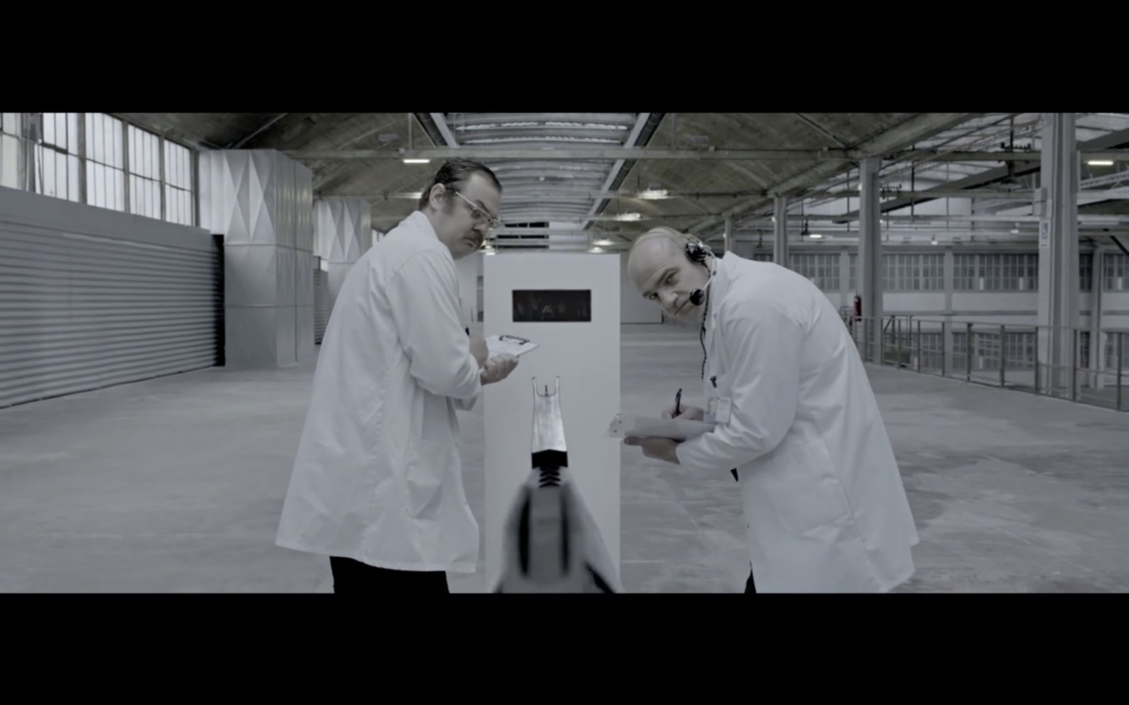 two men in white lab coats looking at something