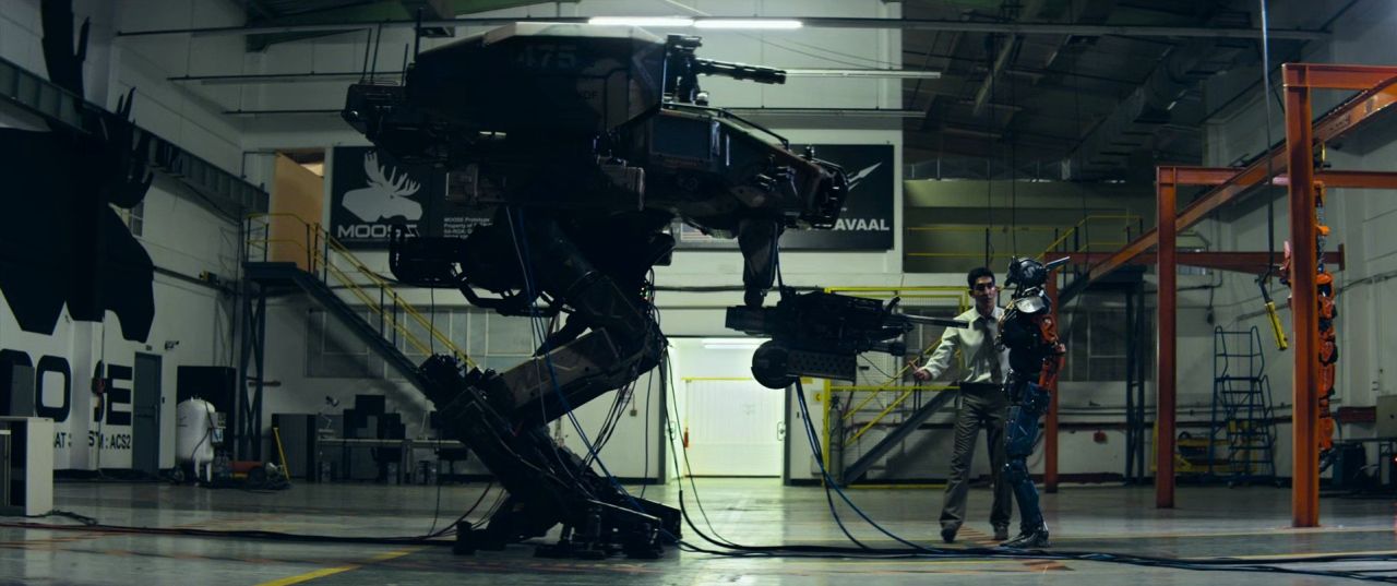 a man standing next to a robot in a warehouse