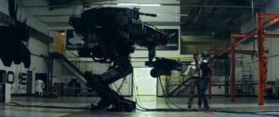 a man standing next to a robot in a warehouse