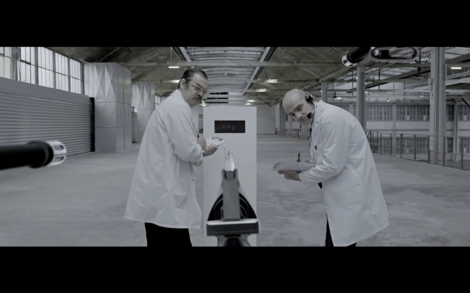 two men in lab coats looking at a machine