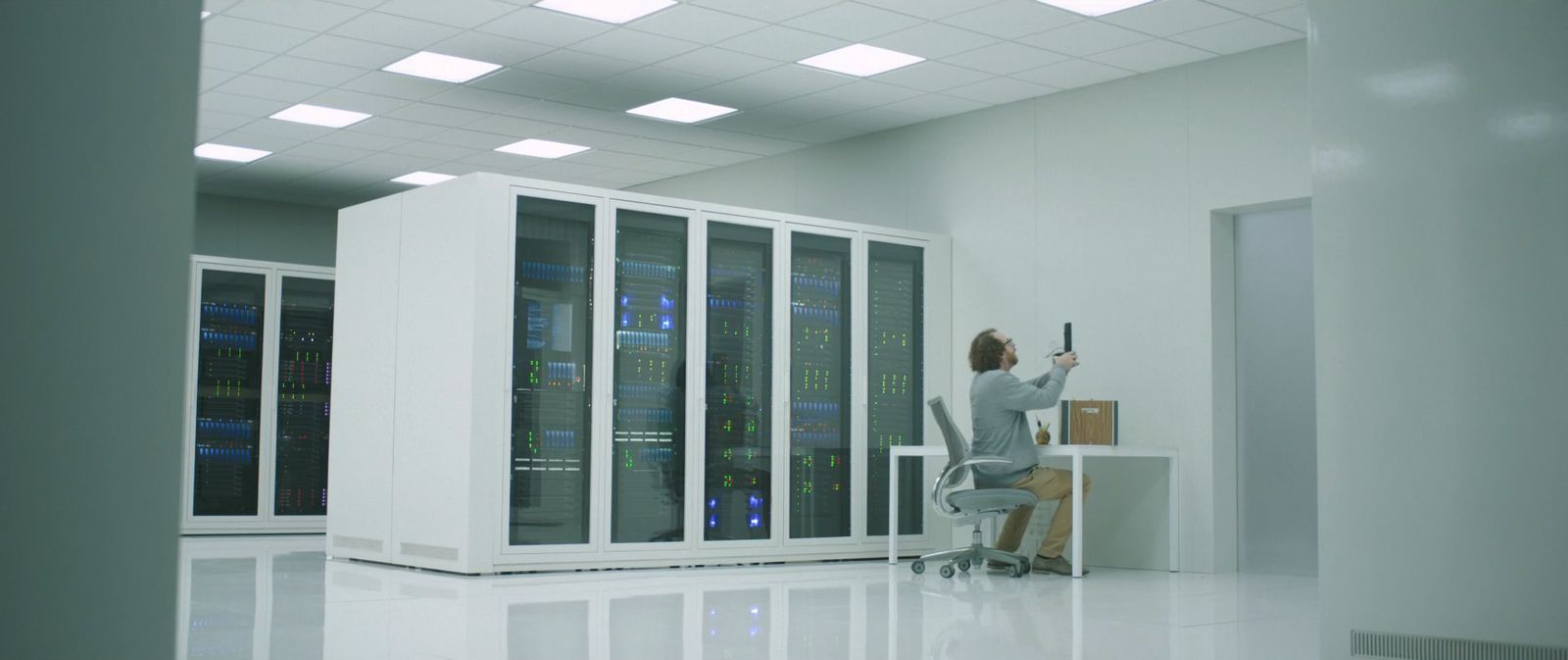 a woman sitting at a desk in a server room