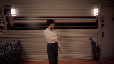 a woman standing in front of a wall in a room