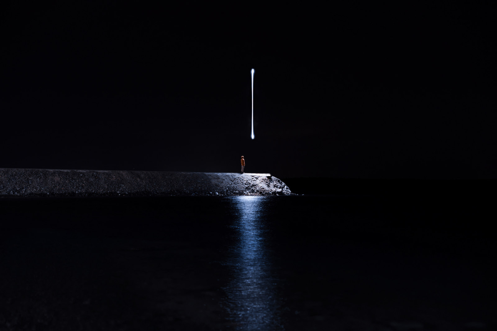 a person standing on a pier at night