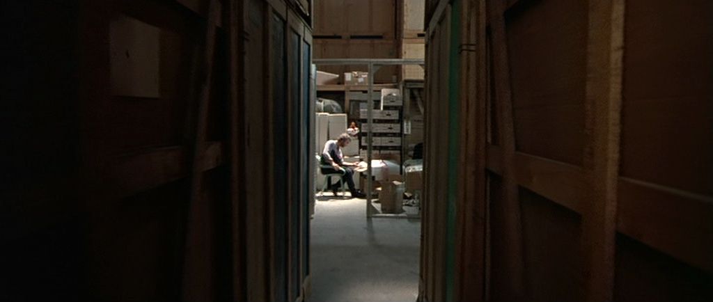 a narrow hallway with a person sitting in a wheel chair