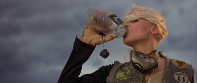 a woman with blonde hair drinking from a water bottle