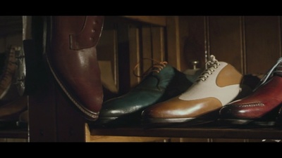 a row of men's shoes sitting on top of a wooden shelf