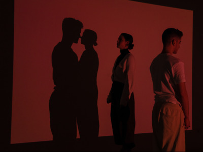 a couple of people standing in front of a red wall