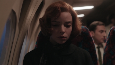 a woman with red hair standing on a train