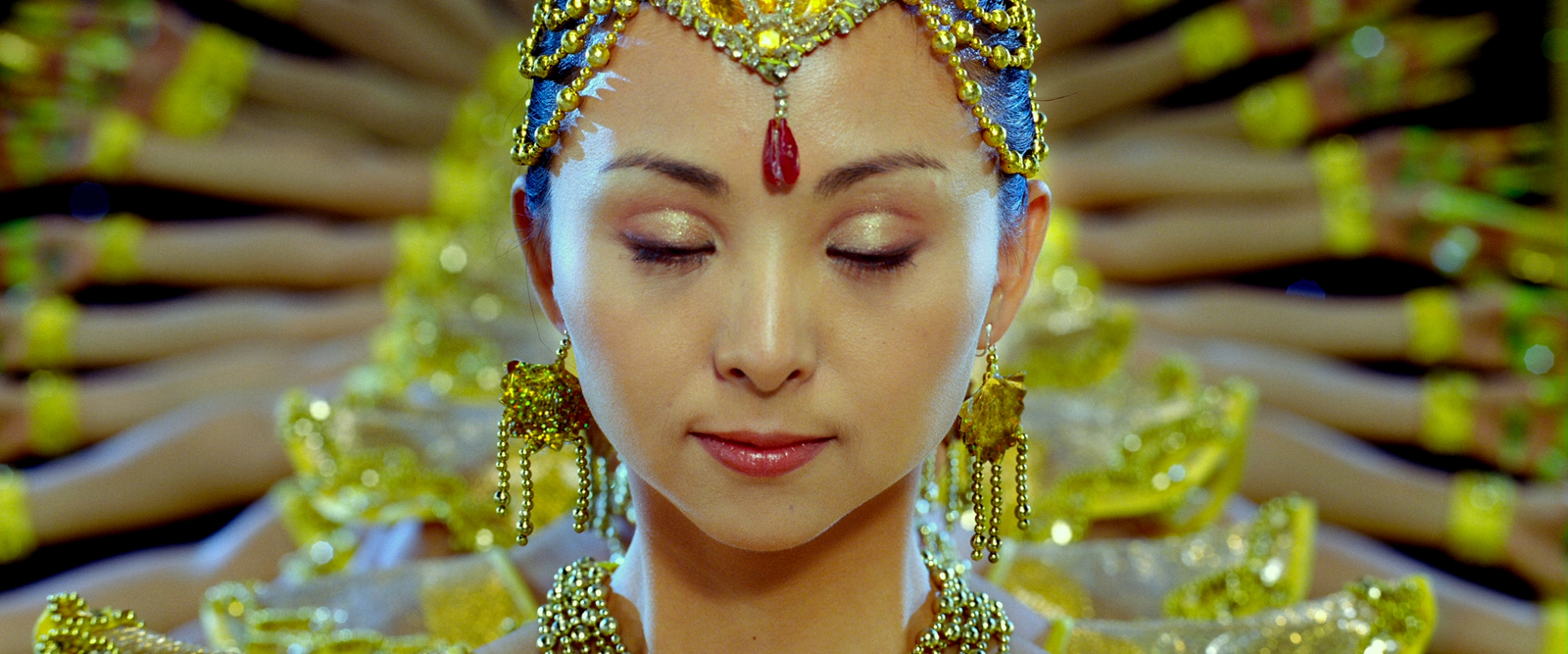 a woman wearing a headdress and gold jewelry