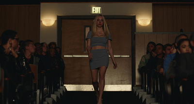 a woman walking down a runway in front of a crowd