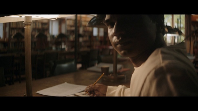 a man sitting at a table with a pen in his hand