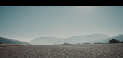 an empty road with mountains in the background